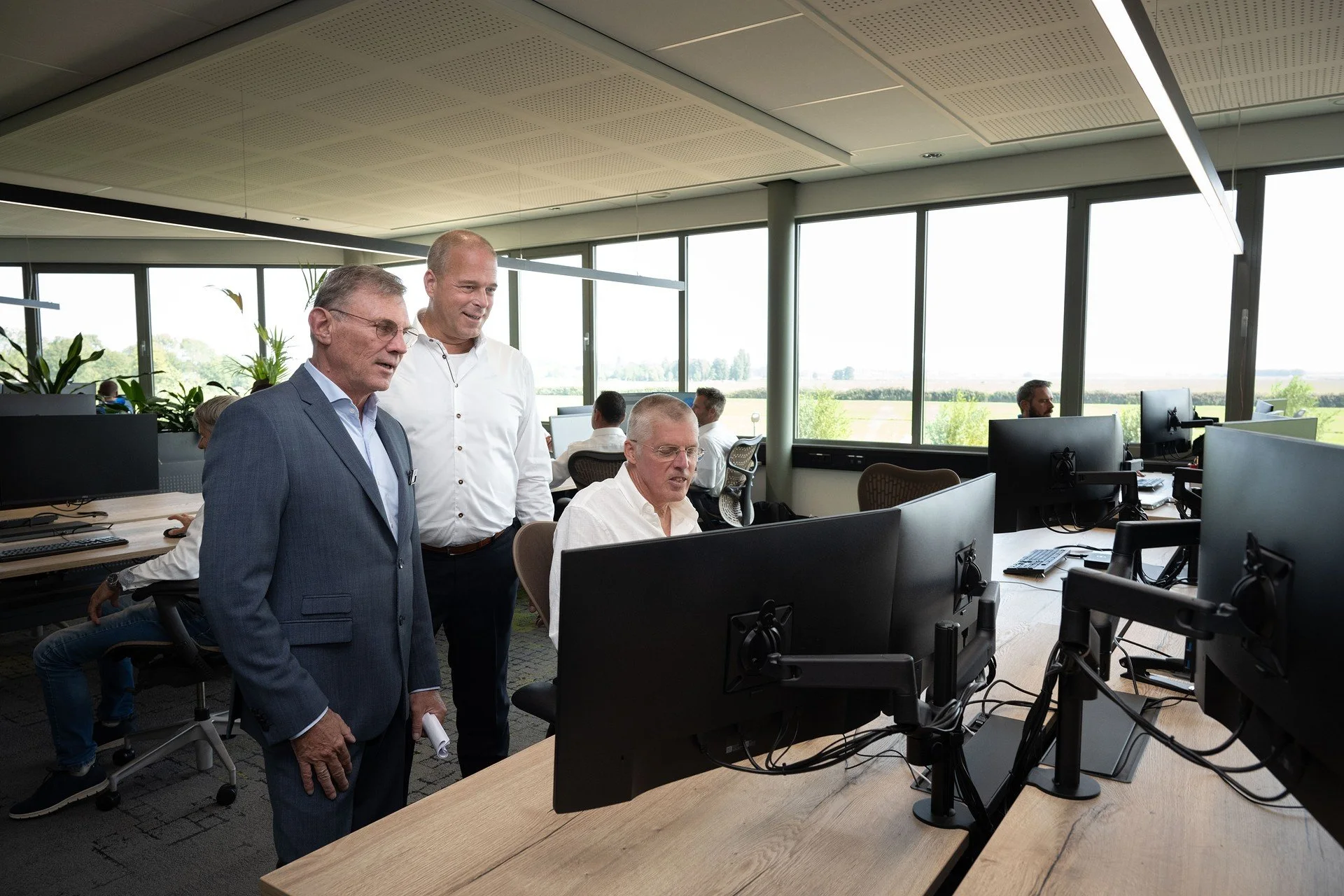 Overleg rond een beeldscherm op een werkplek bij VSE.