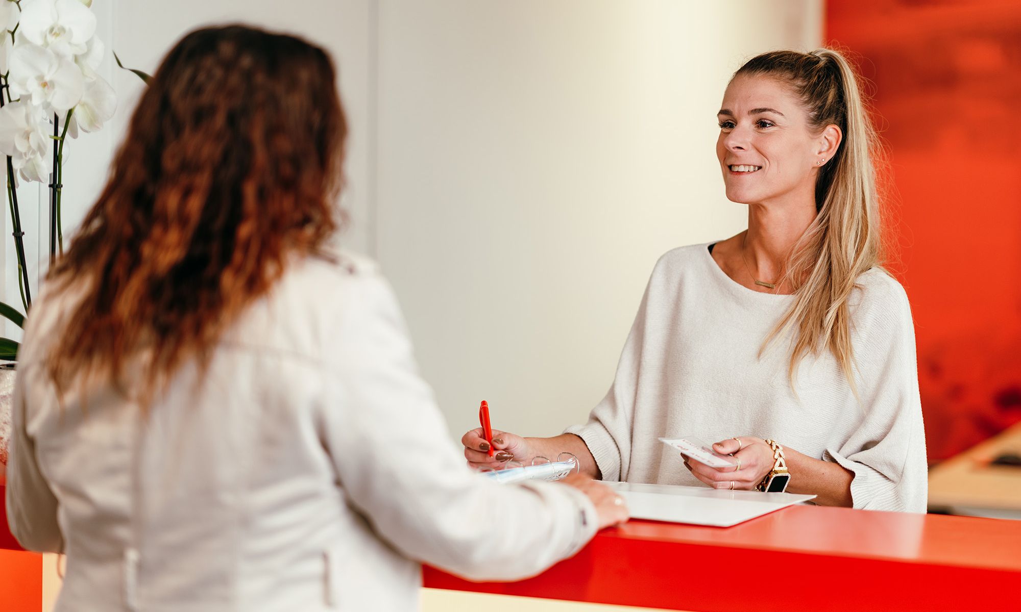 Twee collega's in gesprek aan een balie