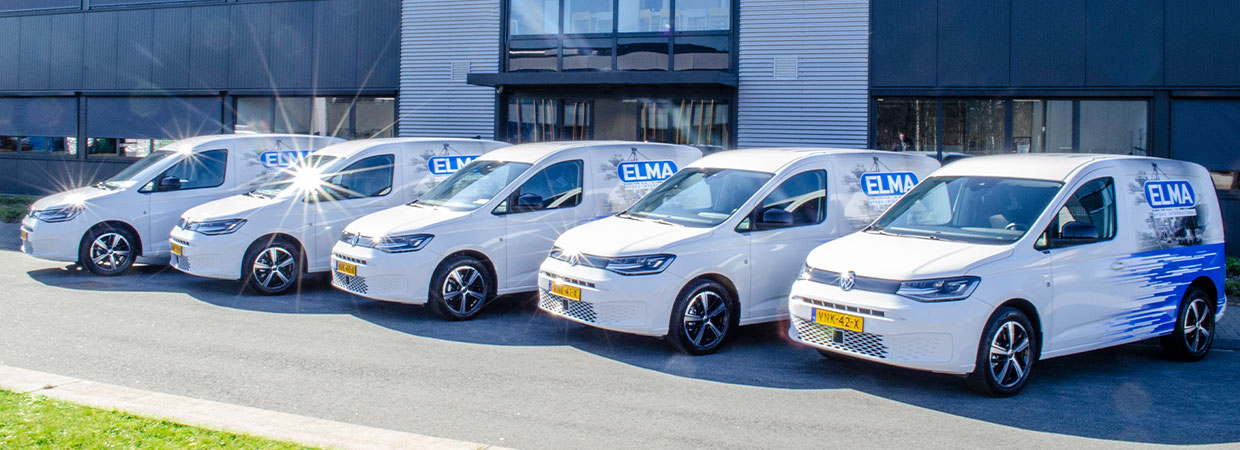 Servicebussen van Elma voor het pand