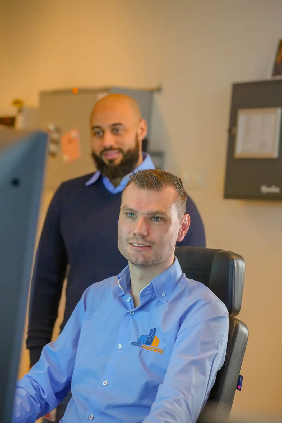 Twee collega's aan een bureau op kantoor (bron: regelpartners.nl)